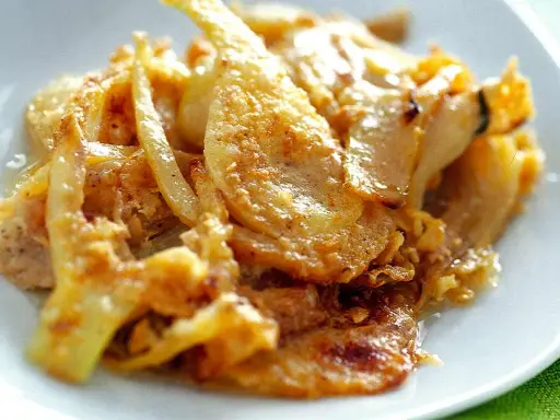 Finoçchi gratinati al forno, un piatto che profuma di casa, servito con un cucchiaio d'argento.