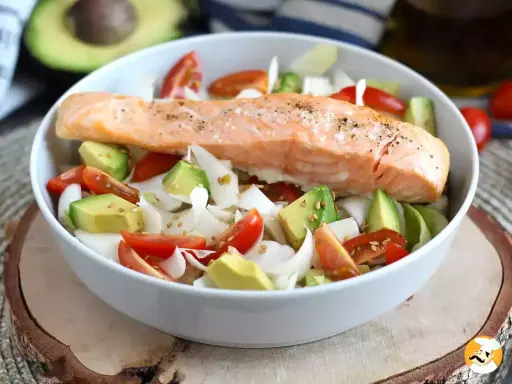 Salmone cotto su un letto di avocado, pomodorini e cipolla bianca, un piatto leggero e gustoso, perfetto come secondi di pesce.