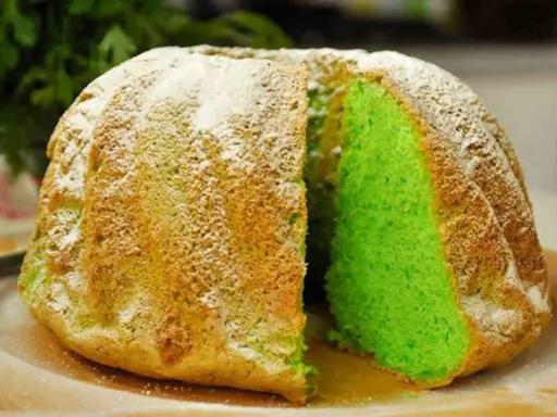 Torta alla menta con un interno verde brillante, cosparsa di zucchero a velo.