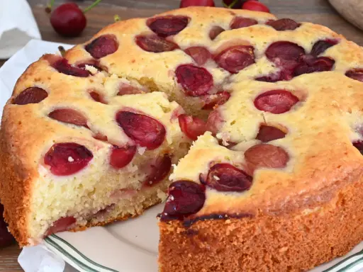 Una deliziosa torta alle ciliegie, con la crosta dorata e tante ciliegie rosse immerse nell'impasto soffice.