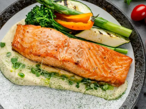 Succulento salmone in friggitrice ad aria su purè cremoso, con verdure grigliate e germogli freschi. Un piatto sano e gustoso.