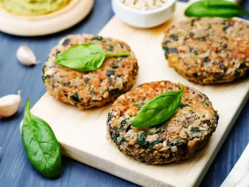 Hamburger di melanzane fatti in casa, guarniti con foglie di spinaci freschi, pronti per essere gustati.