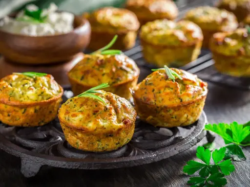 Tortini di zucchine grattugiate dorati e profumati, guarniti con rosmarino, pronti per essere gustati.