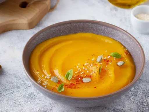 Vellutata di zucca cremosa, guarnita con semi di zucca, sesamo e basilico. Accompagnata da crostini dorati.