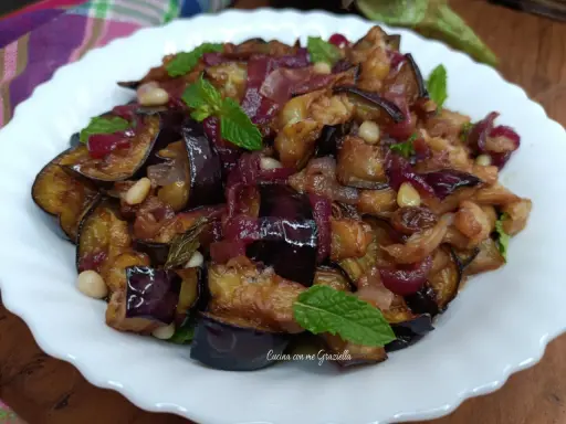 Melanzane in agrodolce, un piatto saporito con cipolle rosse, pinoli e menta fresca. Un'esplosione di gusto!