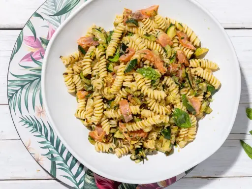 Fusilli con salmone e zucchine, un piatto fresco e colorato, guarnito con basilico.