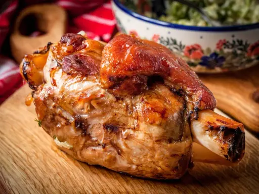 Stinco di maiale al forno, dorato e succulento, pronto per essere gustato.