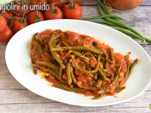 Un piatto di fagiolini in umido, succulenti e saporiti, con pomodoro e cipolla. Un contorno semplice e gustoso.