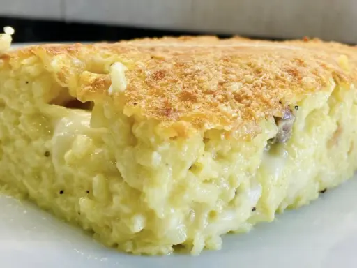 Una fetta di timballo di riso dorato e filante, con un ripieno cremoso e gustoso.
