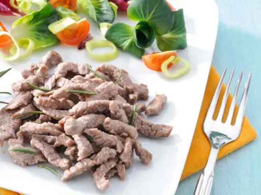 Straccetti di vitello teneri e saporiti, guarniti con rosmarino, accompagnati da un'insalata fresca con pomodorini e cipolla.