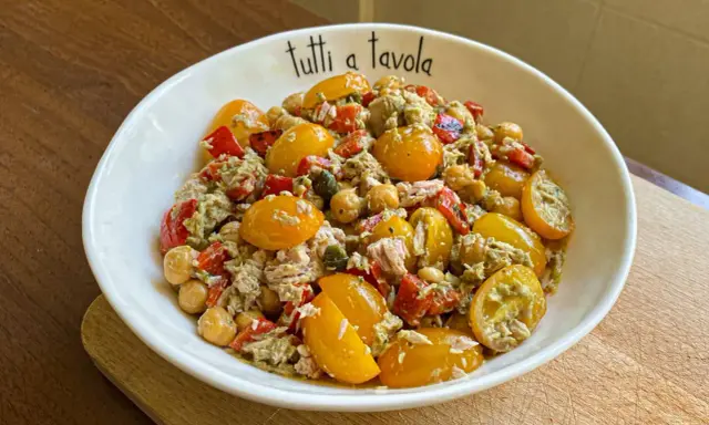 Insalata di tonno con pomodorini gialli, ceci e peperoni rossi, condita con un pesto leggero. Perfetta per un pasto fresco e gustoso.