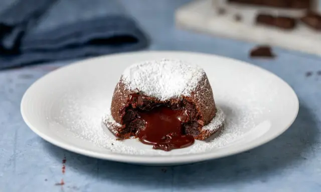 Un tortino al cioccolato con cuore fuso, spolverato di zucchero a velo. Perfetto per dolci morbidi e veloci da preparare.