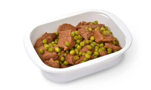 Un saporito spezzatino con piselli in una ciotola bianca, pronto per essere gustato.
