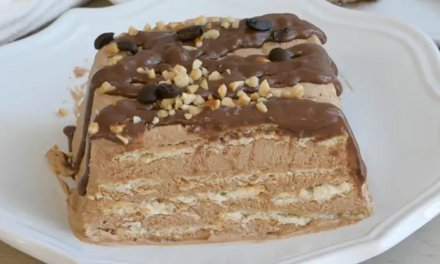 Spumone al caffè a strati, ricoperto di glassa al cioccolato, nocciole tritate e chicchi di caffè.
