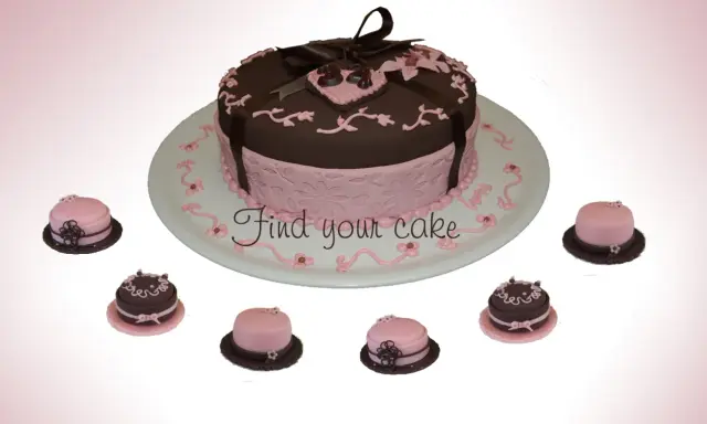 Torta centrale marrone e rosa con decorazioni in pasta di zucchero, circondata da mini-torte.