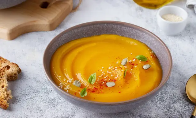 Vellutata di zucca cremosa, guarnita con semi di zucca, sesamo e basilico. Accompagnata da crostini dorati.