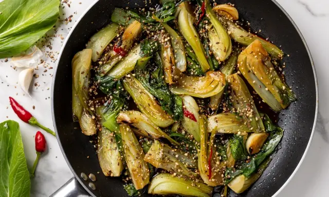 Verdure in padella, bok choy saltato con aglio, peperoncino e semi di sesamo, un piatto saporito e colorato.