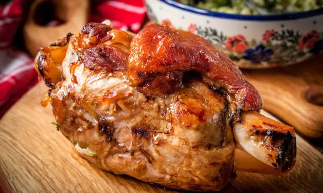 Stinco di maiale al forno, dorato e succulento, pronto per essere gustato.