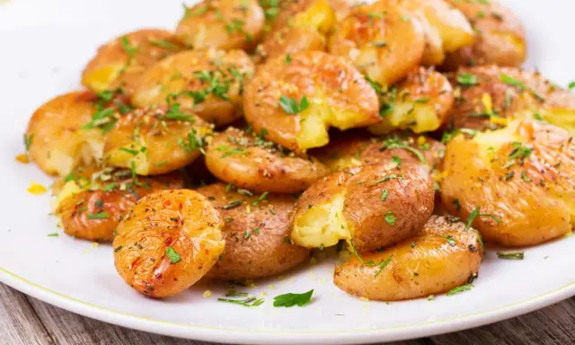 Patate lesse in friggitrice ad aria, croccanti e dorate, condite con erbe aromatiche fresche.