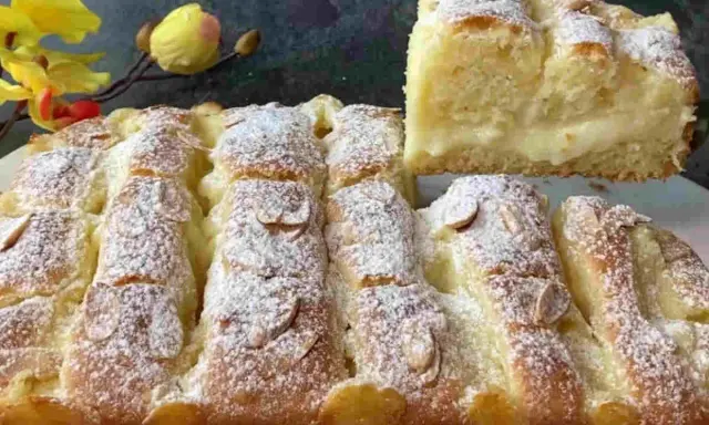Torta al limone velocissima, soffice e profumata, cosparsa di zucchero a velo e mandorle. Una fetta mostra il ripieno cremoso.