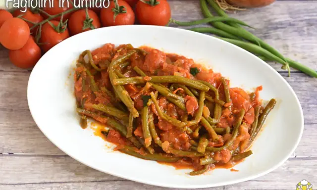 Un piatto di fagiolini in umido, succulenti e saporiti, con pomodoro e cipolla. Un contorno semplice e gustoso.