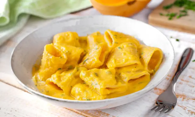 Piatto di pasta e zucca cremoso, con un tocco di erbe aromatiche. Un comfort food autunnale da gustare.