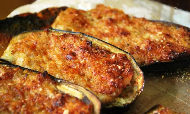 Melanzane ripiene di carne, dorate e gratinate, pronte per essere gustate. Un piatto saporito e invitante.