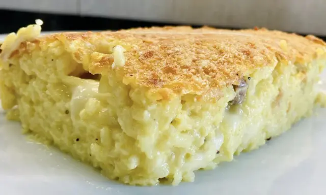 Una fetta di timballo di riso dorato e filante, con un ripieno cremoso e gustoso.