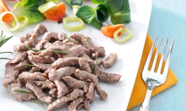 Straccetti di vitello teneri e saporiti, guarniti con rosmarino, accompagnati da un'insalata fresca con pomodorini e cipolla.