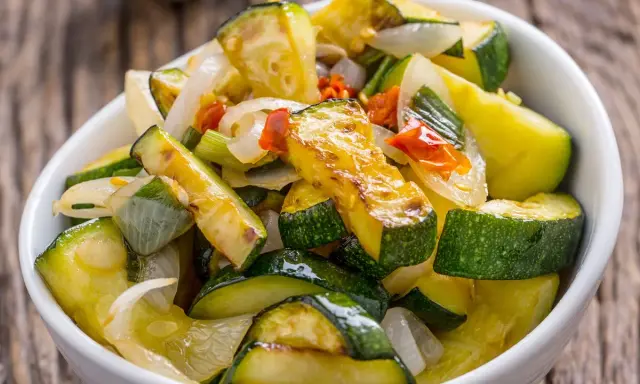 Zucchine in padella, dorate e saporite, con cipolla e pomodoro. Un contorno leggero e gustoso.