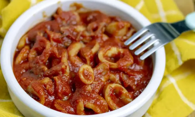 Calamari in umido, un piatto saporito e profumato, servito in una ciotola bianca su un tovagliolo giallo.