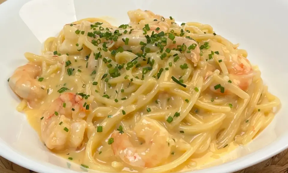 Spaghetti cremosi con gamberi e erba cipollina, una deliziosa carbonara di pesce.