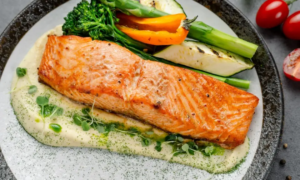 Succulento salmone in friggitrice ad aria su purè cremoso, con verdure grigliate e germogli freschi. Un piatto sano e gustoso.