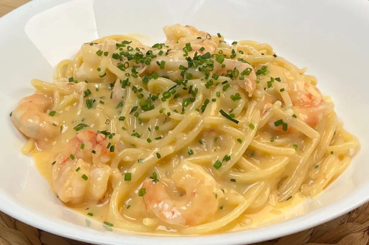 Spaghetti cremosi con gamberi e erba cipollina, una deliziosa carbonara di pesce.