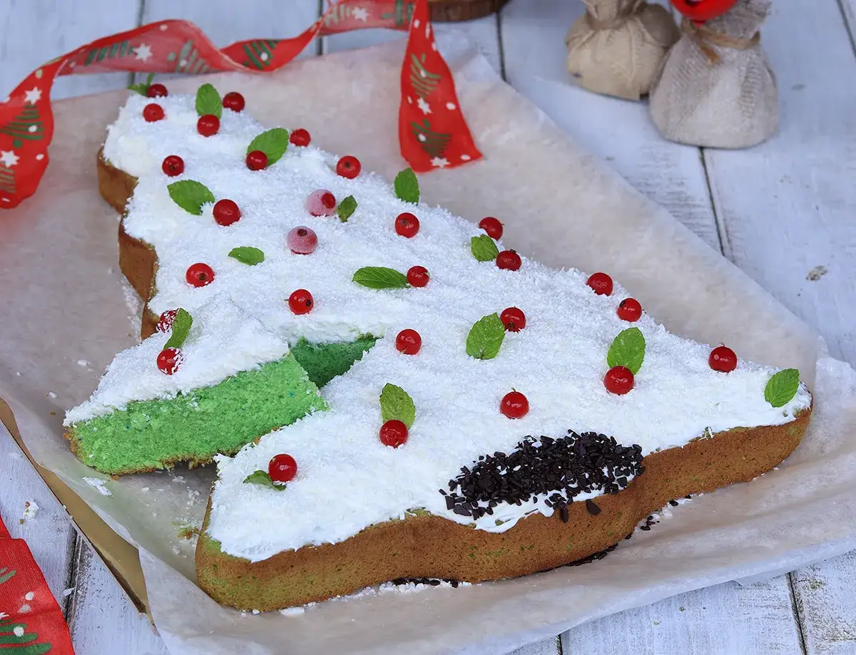 Albero di Natale verde, una torta alla menta decorata con panna, cocco, ribes e foglioline di menta.