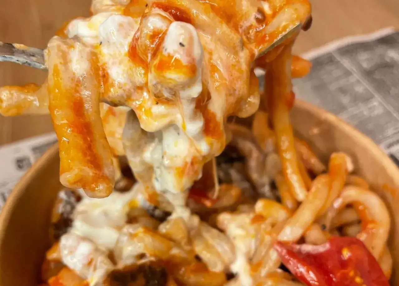 Un primo piatto cremoso e invitante: pasta alla checca con pomodoro e mozzarella filante, un classico della cucina italiana.