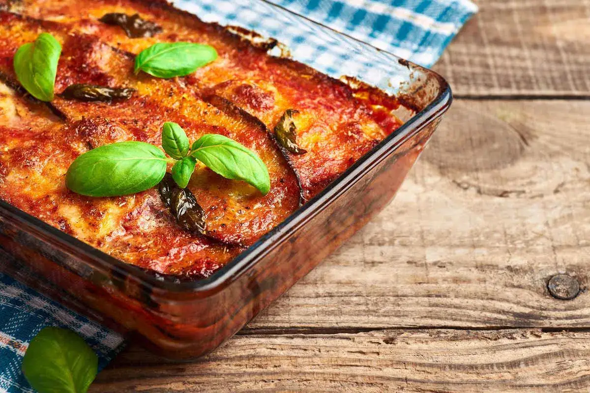 Parmigiana di melanzane in friggitrice ad aria, dorata e profumata, guarnita con basilico fresco. Un classico rivisitato per una cottura pi&ugrave; leggera e veloce.