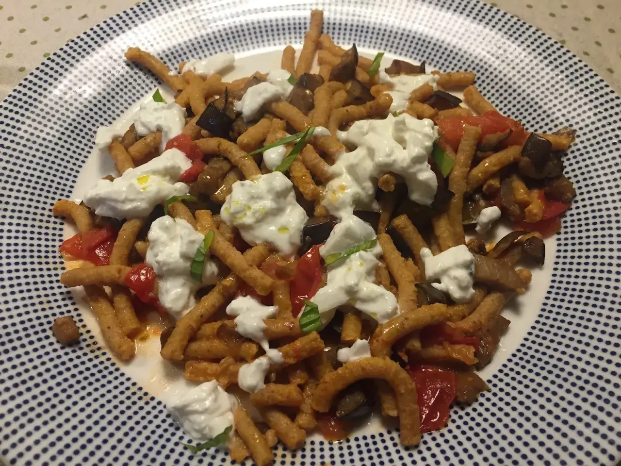 Passatelli asciutti con melanzane e pomodoro, guarniti con burrata fresca. Un piatto gustoso tra le tante ricette da provare.