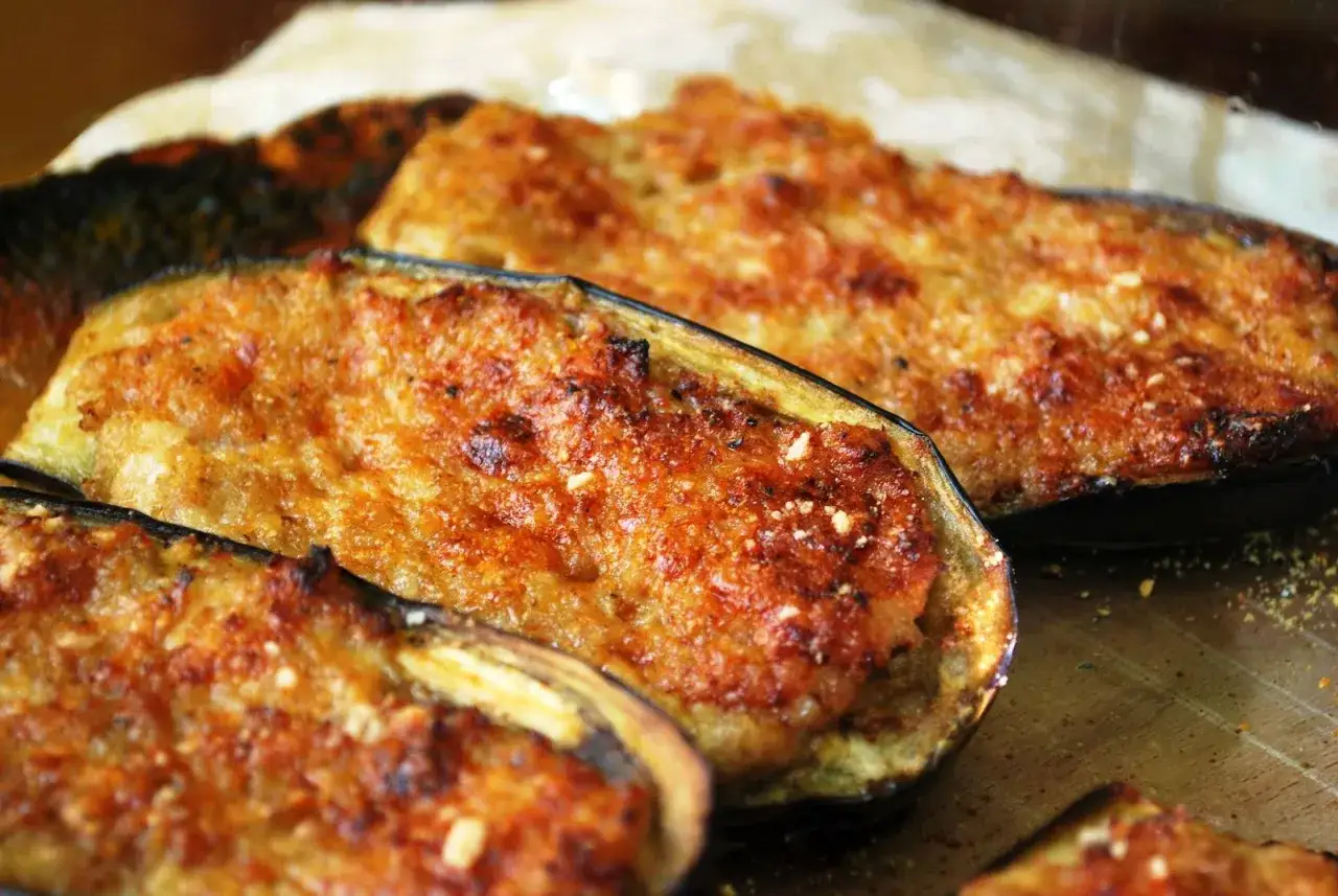 Melanzane ripiene di carne, dorate e gratinate, pronte per essere gustate. Un piatto saporito e invitante.
