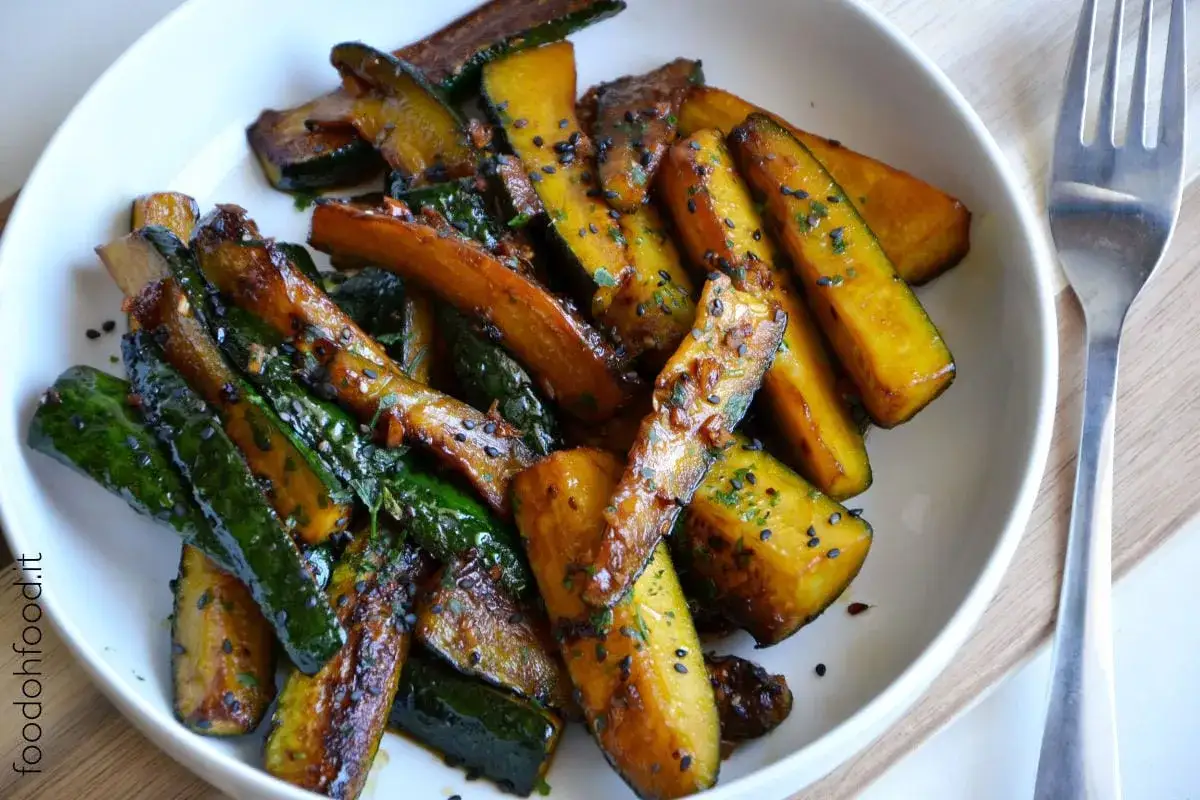 Zucchine in padella caramellate, condite con semi di sesamo nero e erbe aromatiche. Un contorno saporito e colorato.