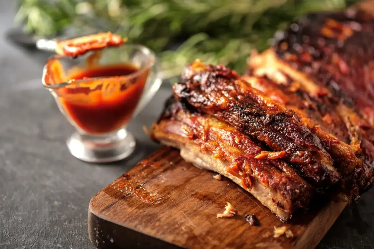 Succulente costine di maiale glassate, pronte per essere gustate con la loro salsa barbecue.
