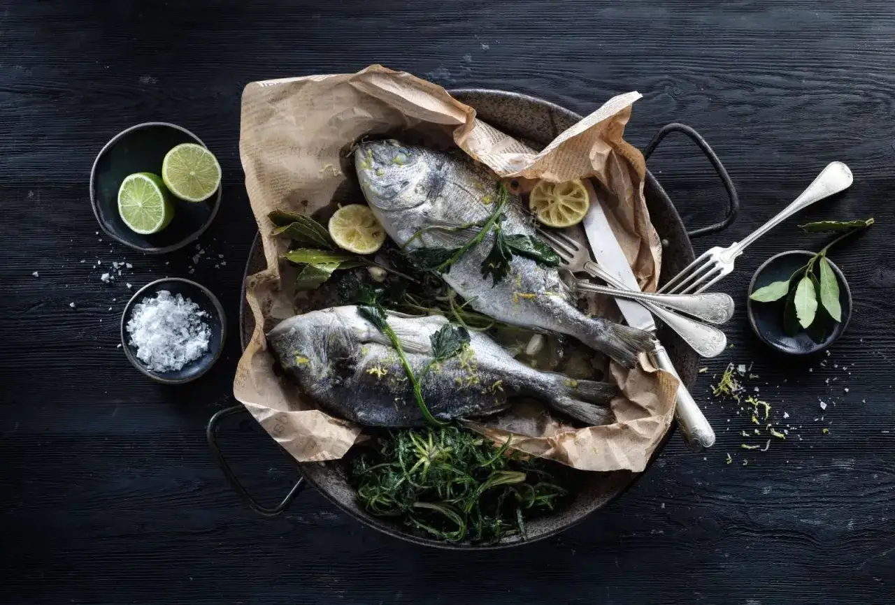 Orate cotte in friggitrice ad aria, servite con limone, erbe aromatiche e sale grosso.