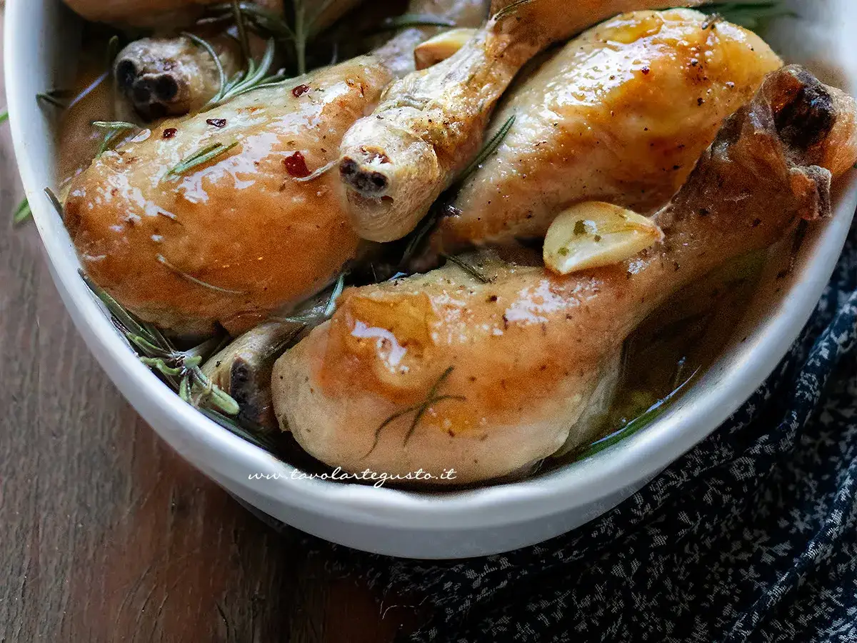 Cosce di pollo succulente in una teglia con aglio e rosmarino, pronte per essere gustate.