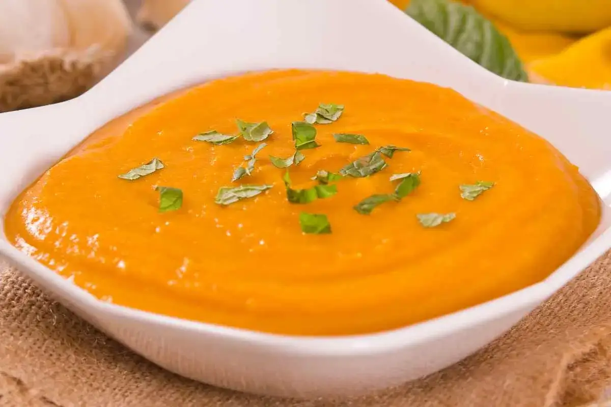 Crema vellutata di zucca, guarnita con basilico fresco. Un piatto confortante che unisce la dolcezza della zucca alla consistenza della pasta.