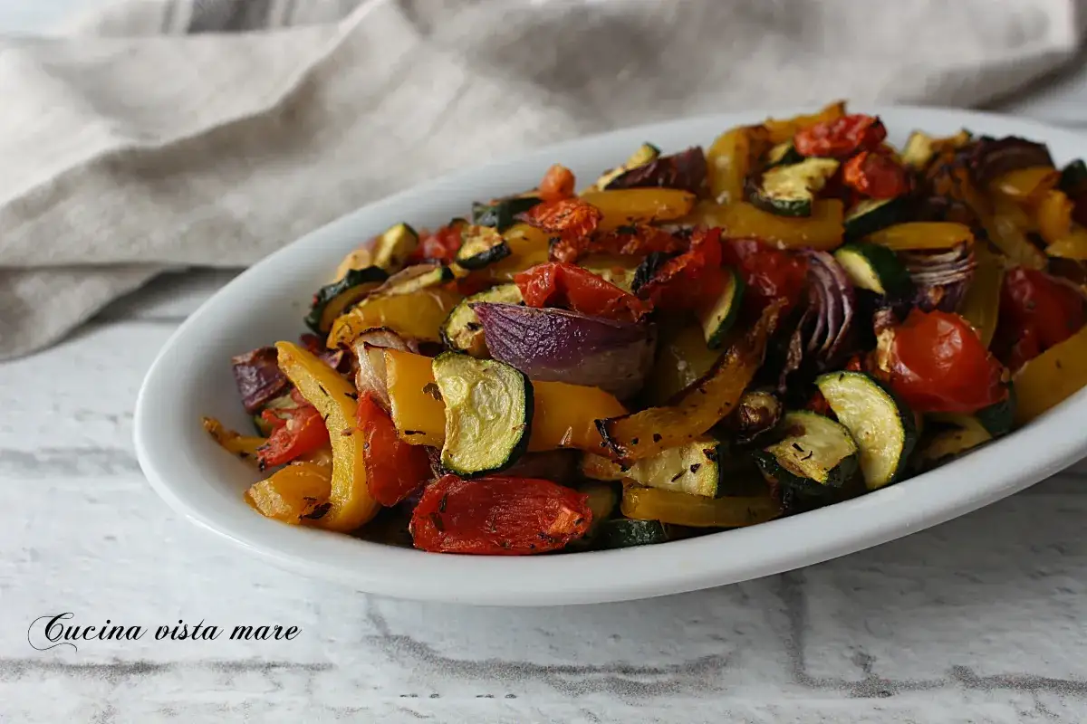 Un piatto invitante di verdure miste, tra cui zucchine, peperoni gialli e pomodorini, cotte alla perfezione nella friggitrice ad aria.
