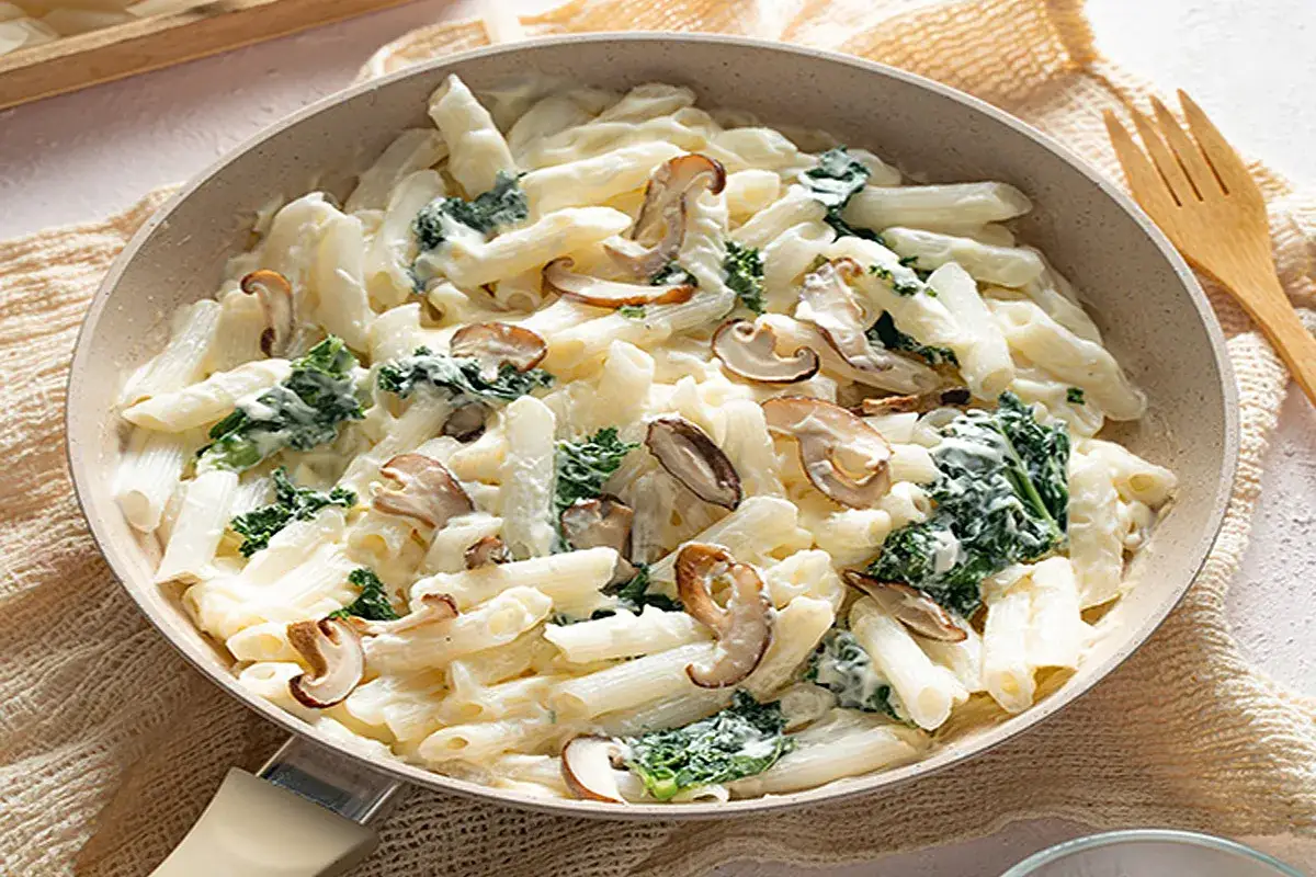 Penne cremose con funghi e spinaci, un piatto invitante e saporito.