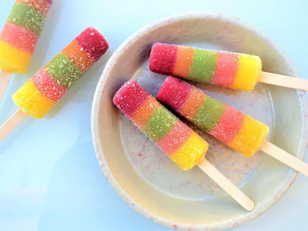 Ghiaccioli di frutta frullata senza zucchero, colorati e ghiacciati, su un piatto.