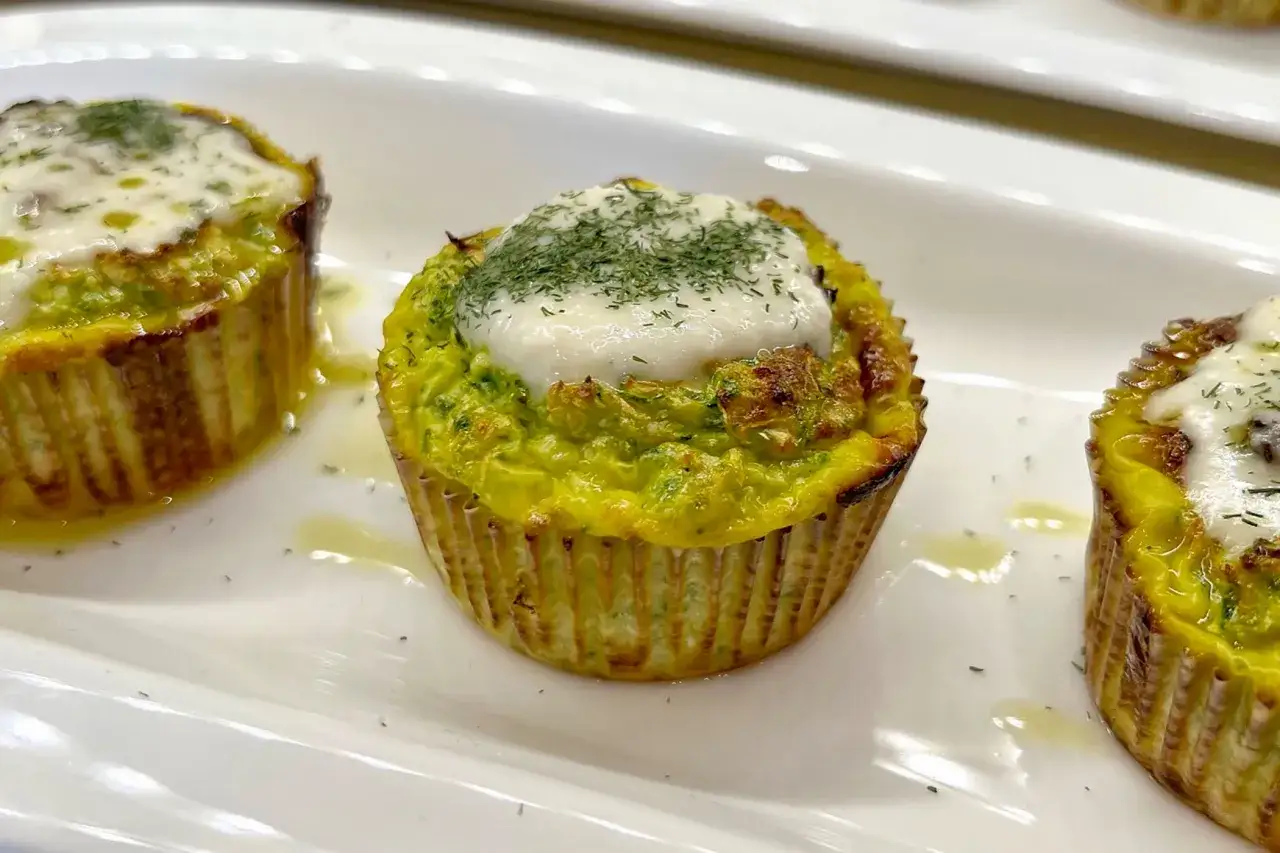 Deliziosi tortini di zucchine grattugiate, dorati e guarniti con formaggio fuso e erbe aromatiche.