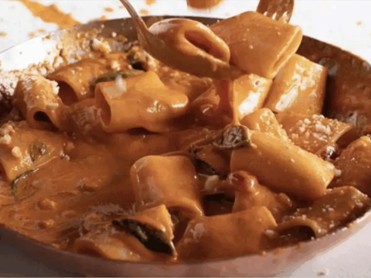Un primo piatto cremoso e invitante: paccheri alla Vittorio, ricchi di sugo all'arancia e guarniti con parmigiano.