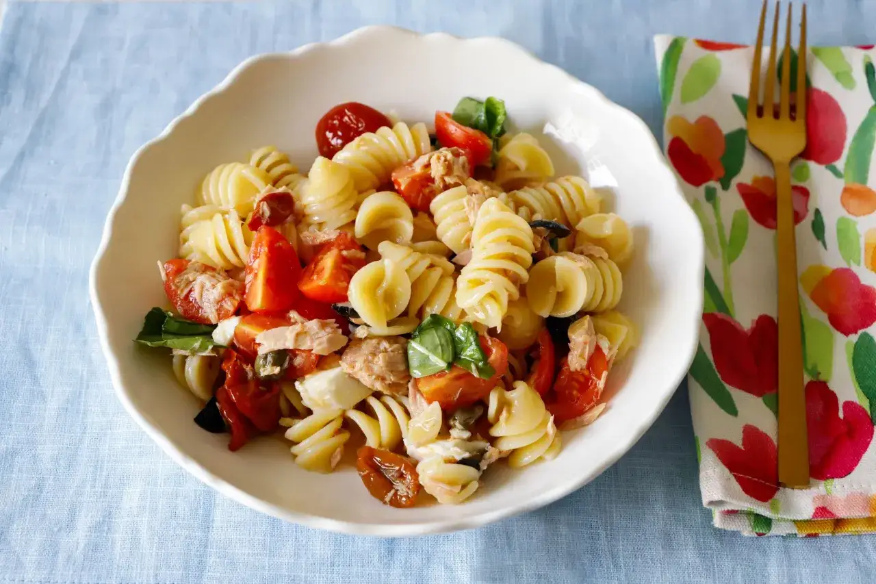 Piatto di pasta tonno e pomodorini freschi e secchi, con basilico e olive nere. Un classico estivo.